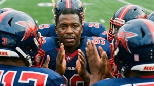Michael Irvin leading the huddle with teammates.