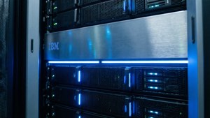 Close-up of server rack with blue lights and IBM logo reflection.