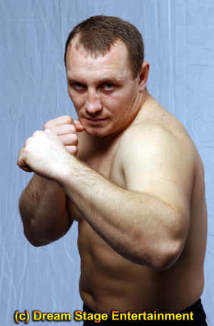 A muscular man in a fighting stance with fists raised, looking intensely at the camera. — Igor Vovchanchyn Picture