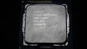 Chip CPU Intel Core i3-3220 polveroso con testo visibile e graffi.
