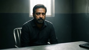 Lawrence Bishnoi sidder stoisk i et forhørslokale under et skarpt lys.