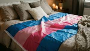 Bisexual flag elegantly draped on a bed in romantic lighting.