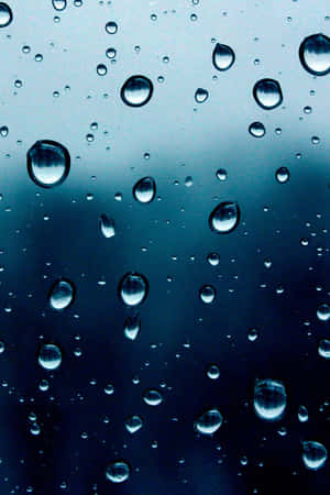 Raindrops on glass with blue gradient background