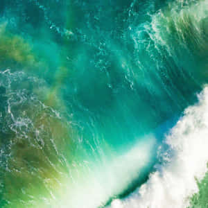 Aerial shot of turquoise ocean waves crashing with white foam.