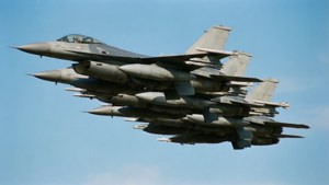 Aviones de combate militares vuelan en formación cerrada contra un cielo azul claro.
