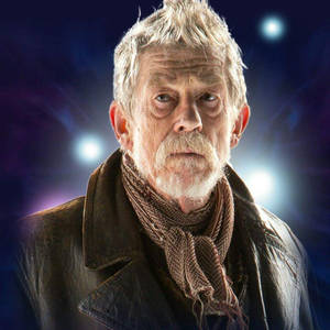 En äldre man med vitt hår och skägg i en läderjacka och halsduk mot en kosmisk bakgrund. — John Hurt Bakgrundsbilder