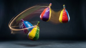 Vários hacky sacks malabarizados com rastros de luz em estúdio escuro