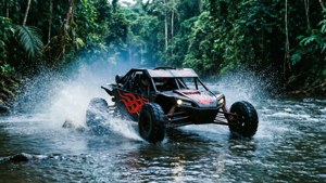Un buggy negro con llamas atraviesa a toda velocidad un río poco profundo de la jungla.