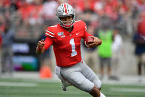 Football-quarterback springer med bollen på planen under en match. — Justin Fields Bilder