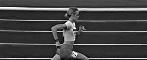 Female sprinter in midrace on a track wearing number 7 — Hoatzin Picture