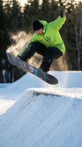 Snowboarder, der laver en 360-spin fra en knuckle i et slopestyle-løb.