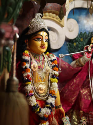 En dekoreret hinduistisk gudindestatue i et tempel med blomsterkranse og guldsmykker. — Lord Vishnu Wallpapers