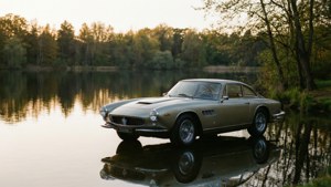 Maserati 3500 GT vid en sjö under gyllene timmen med vattenspegling.