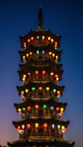 A vertical phone wallpaper of a multi-tiered lantern tower with colorful lights.