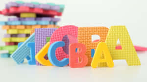 Colorful foam letters spelling CBA with stacks of other letters in background. — Learning Background