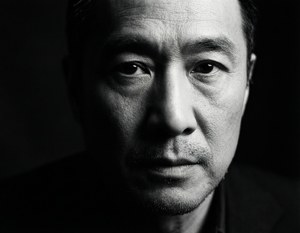 Dramatisk sort-hvid chiaroscuro-portræt af Edward Yang med intens blik
