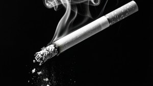 Um papel de parede dramático em preto e branco de um cigarro com uma longa cinza, iluminado lateralmente.