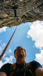 Een eerstepersoonsbeeld vanuit het perspectief van een klimmer die omhoog kijkt naar de route en de lucht.