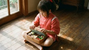 Chihiro nyter en bentoboks i et solfylt rom.
