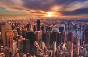 New York City skyline at sunset with golden light on skyscrapers and rivers. — Aesthetic Mac Wallpaper