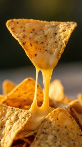 Makro foto af en nachochip med et strækbart ostetræk.