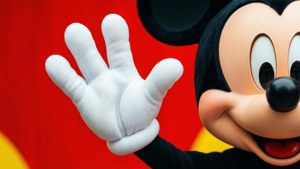 A close-up of Mickey Mouse's hand waving in a cheerful pose.