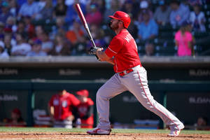 Baseball player swinging bat during daytime game with spectators in background. — Live Wallpaper