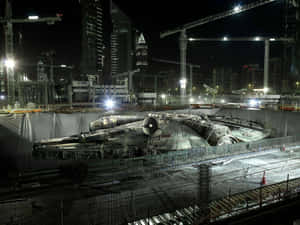 Millennium Falcon spaceship under construction at night in a city. — Millenium Falcon Picture