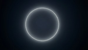 Elegant dark wallpaper featuring a softly glowing white dashed circle at the center.