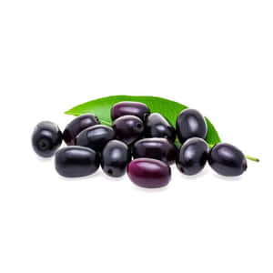 Glossy black jujubes with a green leaf on white background — Plum Background