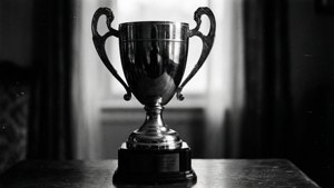 Una foto in bianco e nero ad alto contrasto di un trofeo con grana della pellicola e ombre drammatiche.