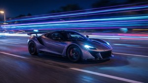 Neonvalaistu urheiluauto liikelinjoineen yöllä.
