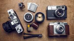 Fotocamere e obiettivi vintage su tavolo di legno