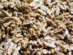 A pile of shelled walnuts with detailed ridged surfaces. — Fresh Wallpaper