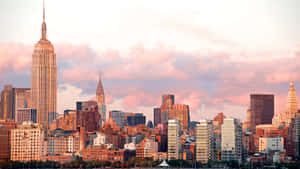 Skyline de New York au coucher du soleil avec des nuages roses et des gratte-ciel emblématiques. — New York City Fonds d'écran