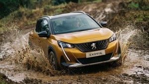 Yellow Peugeot 2008 off-roading through mud and water splashes