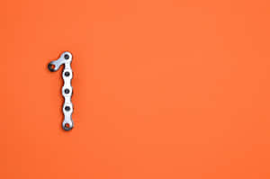 Bicycle chain shaped like the number one on orange background — Orange Desktop Picture