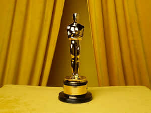 Golden Oscar statue on yellow velvet with golden curtains behind. — Oscars Picture