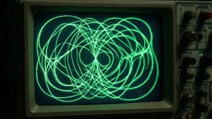 Retro sci-fi-taustakuva oskilloskoopin näytöstä, jossa on hehkuvia vihreitä Lissajous-kuvioita