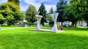 A joyful park scene in Yverdon-les-Bains with a modern sculpture and children playing. — Yverdon Les Bains Wallpaper