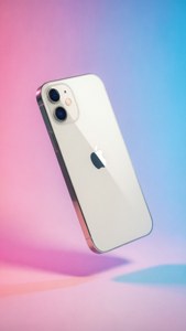 iPhone 12 kelluu pastelliliukuväritaustalla, vaaleanpunainen ja sininen, minimalistinen.