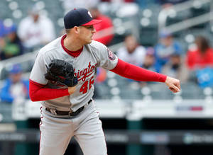 Lanzador de béisbol con uniforme de Nationals en medio del lanzamiento en el estadio — Escritorio Fondos de pantalla