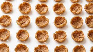 Grid pattern of Cinnamon Toast Crunch cereal pieces on white