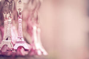 Pink Eiffel Tower keychains as travel souvenirs with soft background blur. — Eiffel Wallpaper