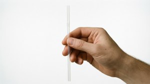 Et minimalistisk studieoptag af et plastik sugerør, der fokuserer på udbredelsen og spildet af engangsplastik.