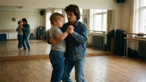 Intimate dance practice scene with mirror reflection.