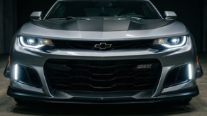 Une Camaro de face avec des phares menaçants en lumière de studio.