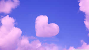 A pink heart-shaped cloud in a blue sky surrounded by soft clouds. — Beautiful Cool Wallpaper