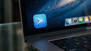 A realistic close-up of the Preview app icon on a MacBook with a starry night background.