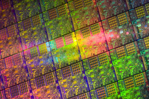 Primo piano di un wafer di microchip colorato con motivi circuitali luminosi.